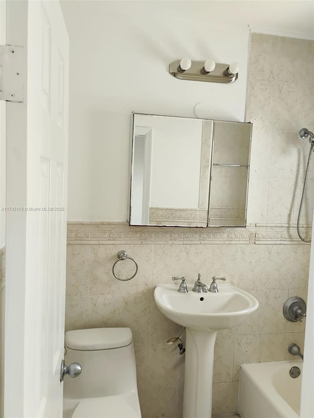 bathroom with toilet,  shower combination, and tile walls