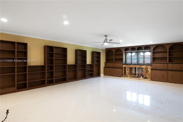 unfurnished living room with built in features, ornamental molding, and ceiling fan