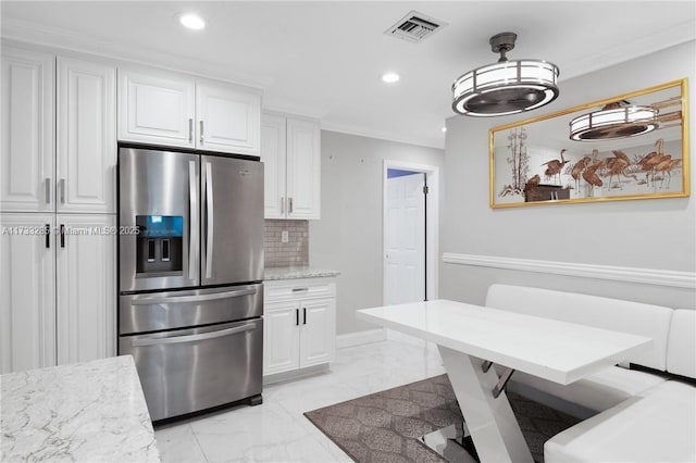 kitchen featuring white cabinetry, crown molding, decorative backsplash, light stone counters, and stainless steel refrigerator with ice dispenser