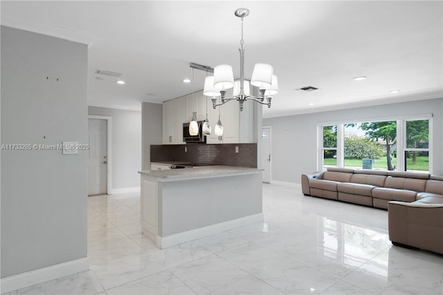 kitchen with light stone counters, crown molding, decorative light fixtures, white cabinets, and backsplash