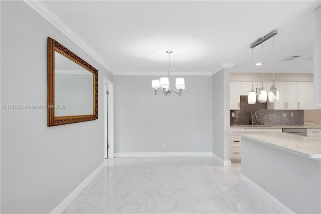 unfurnished dining area featuring crown molding, a chandelier, and sink