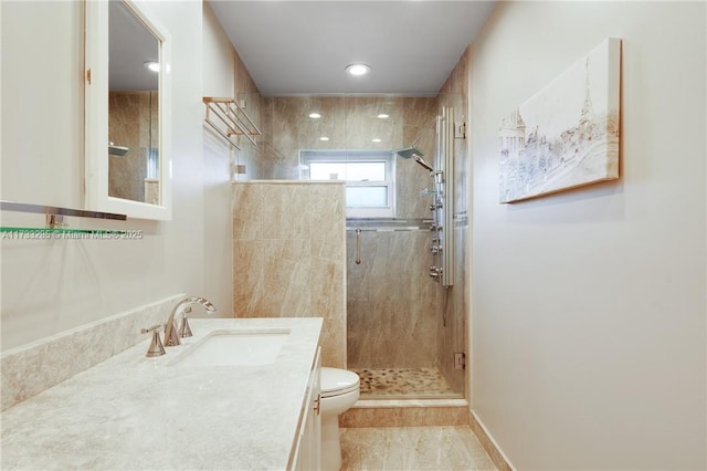 bathroom featuring vanity, a shower with shower door, and toilet