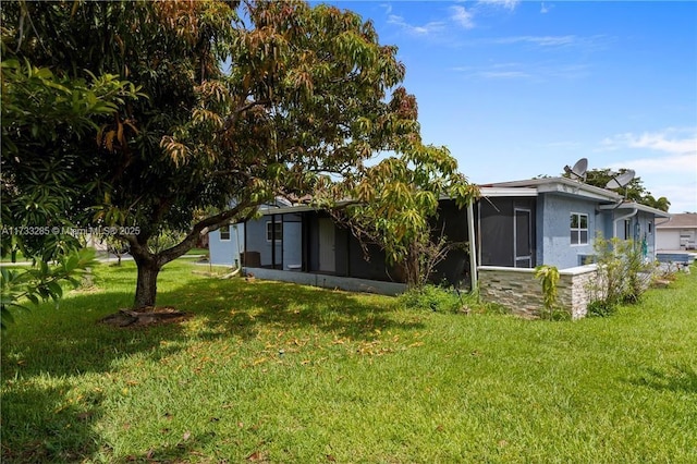 rear view of property with a sunroom and a lawn