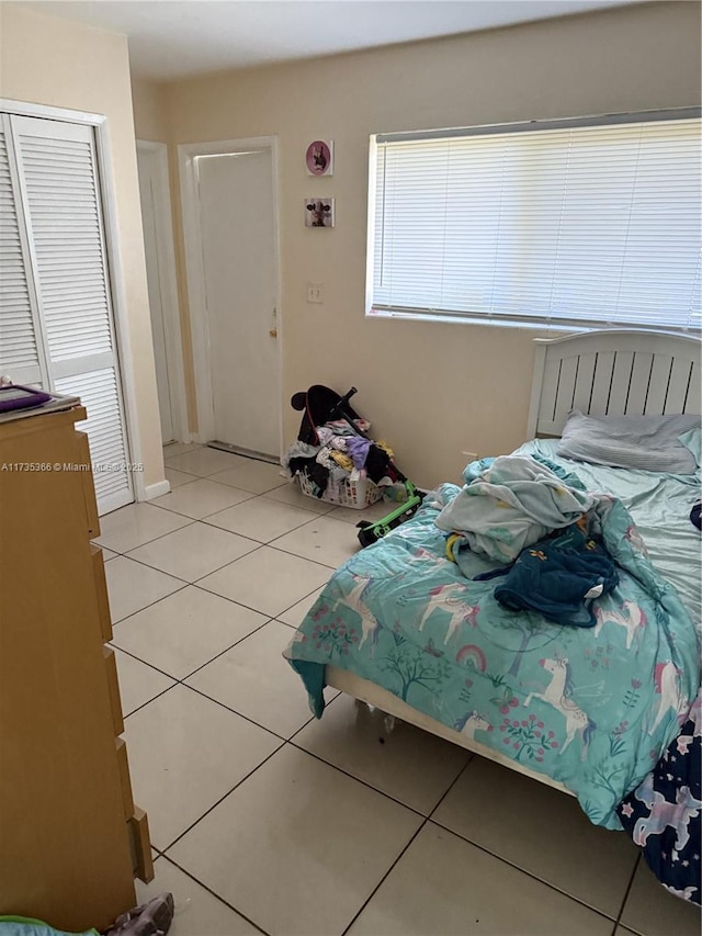 bedroom featuring light tile patterned floors and a closet