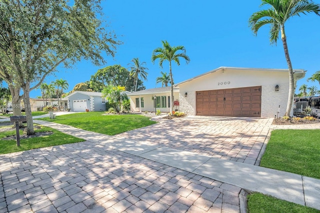 single story home featuring a garage and a front lawn