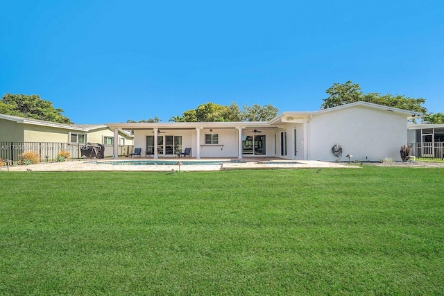 back of house featuring ceiling fan, a patio area, and a lawn