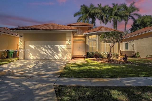 mediterranean / spanish house featuring a garage and a lawn