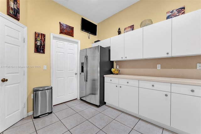 kitchen with white cabinetry, stainless steel fridge with ice dispenser, and light tile patterned floors