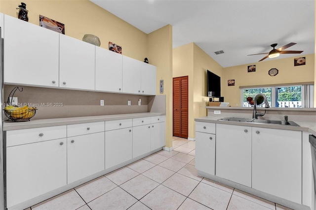 kitchen with sink, light tile patterned floors, white cabinets, and ceiling fan