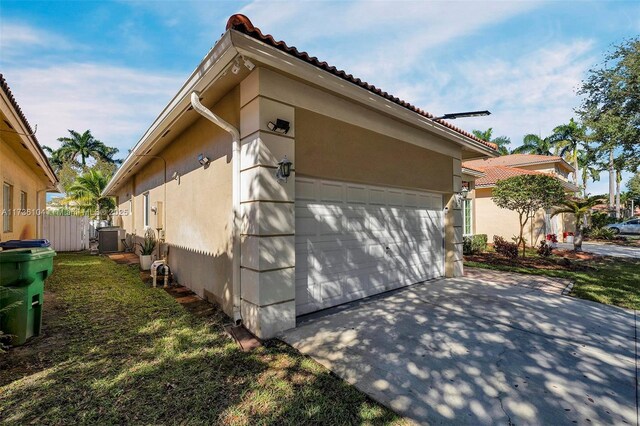 view of side of property featuring a garage and central AC