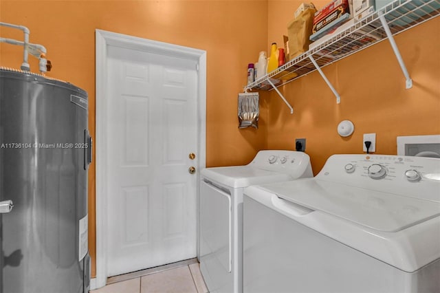 washroom with separate washer and dryer, light tile patterned floors, and electric water heater