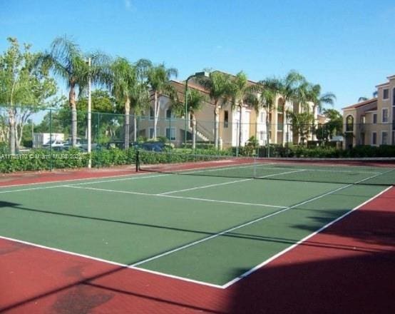 view of tennis court featuring community basketball court and fence