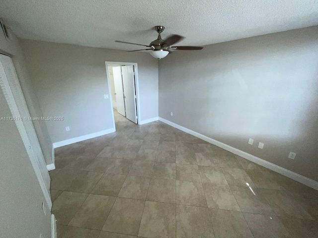 spare room featuring a ceiling fan, baseboards, and a textured ceiling