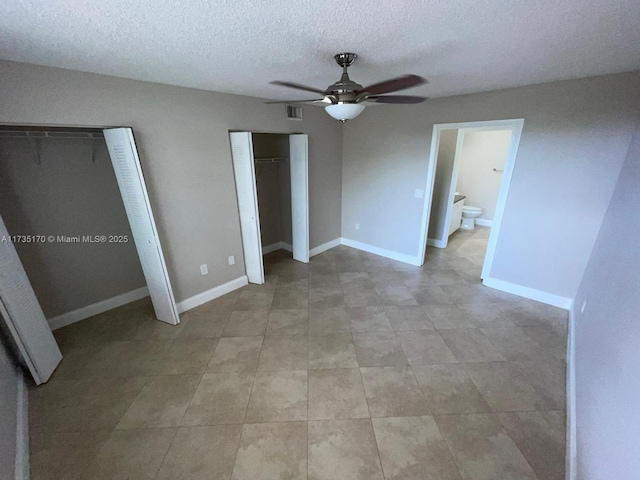unfurnished bedroom featuring visible vents, two closets, a ceiling fan, a textured ceiling, and baseboards