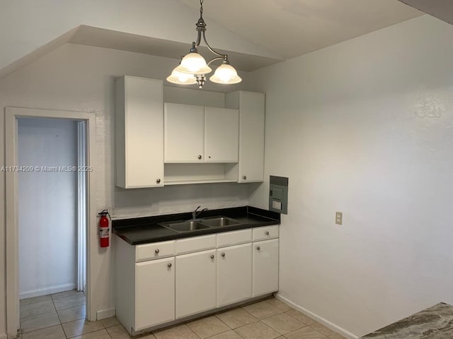 kitchen with lofted ceiling, sink, light tile patterned floors, white cabinets, and decorative light fixtures