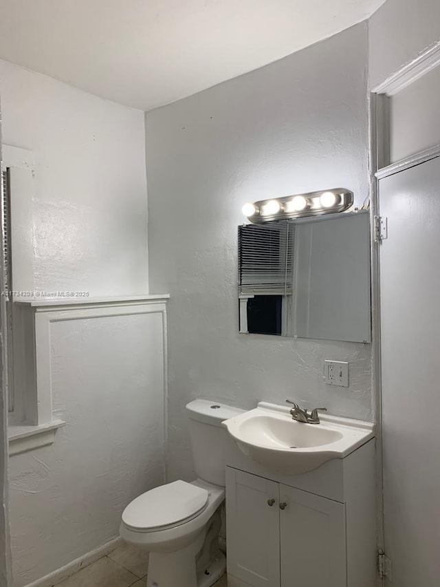 bathroom featuring vanity, tile patterned floors, and toilet