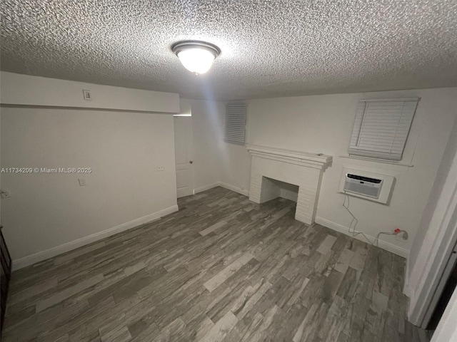 laundry area with a wall unit AC, dark hardwood / wood-style floors, and a textured ceiling