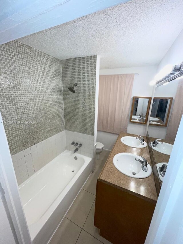 full bathroom with tile patterned floors, toilet, a textured ceiling, and vanity