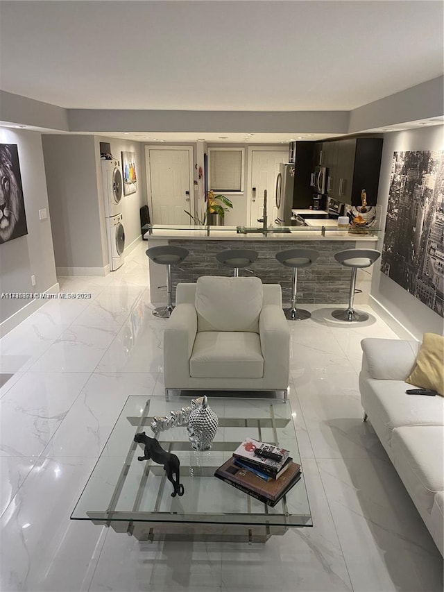 living room with stacked washer and dryer and sink