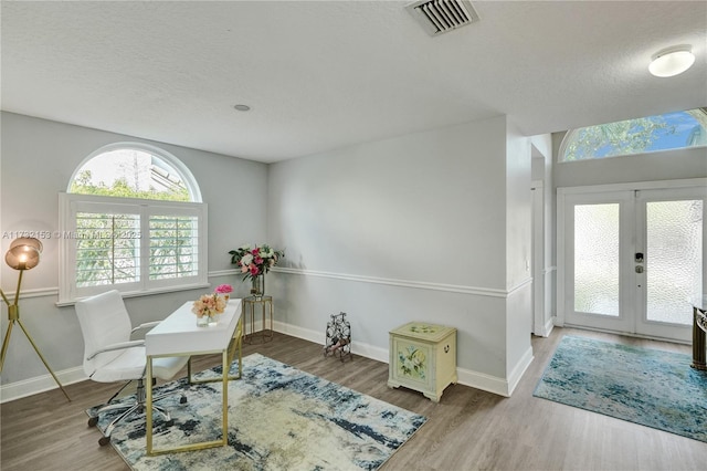 office area with hardwood / wood-style flooring, french doors, and a textured ceiling