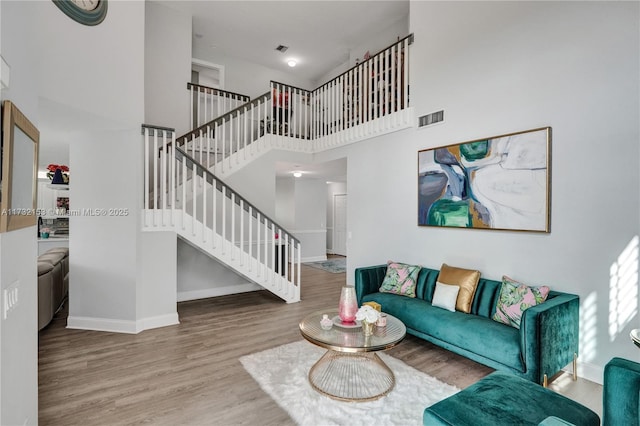 living room with a towering ceiling and hardwood / wood-style floors