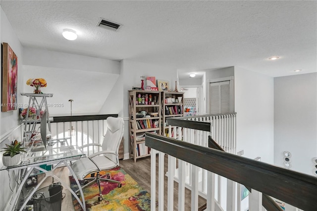 hallway with dark hardwood / wood-style floors and a textured ceiling