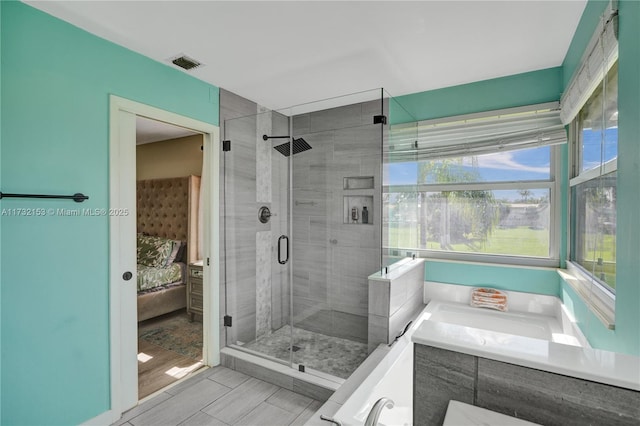 bathroom featuring a shower with door and vanity