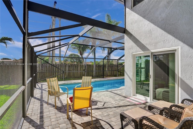 view of pool with glass enclosure and a patio area