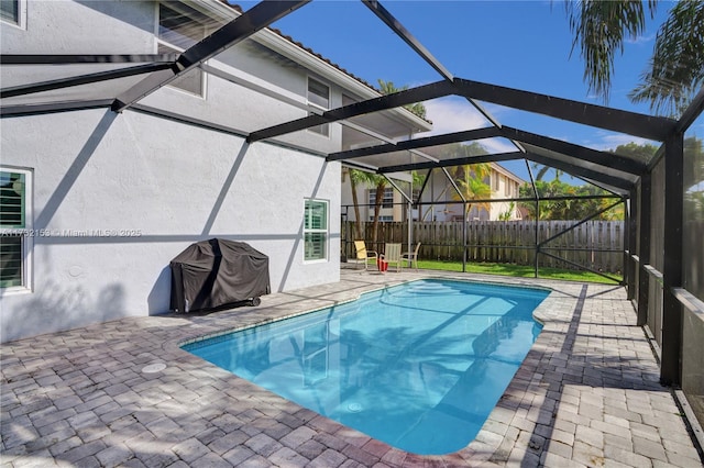 view of swimming pool with a patio, a lanai, and grilling area