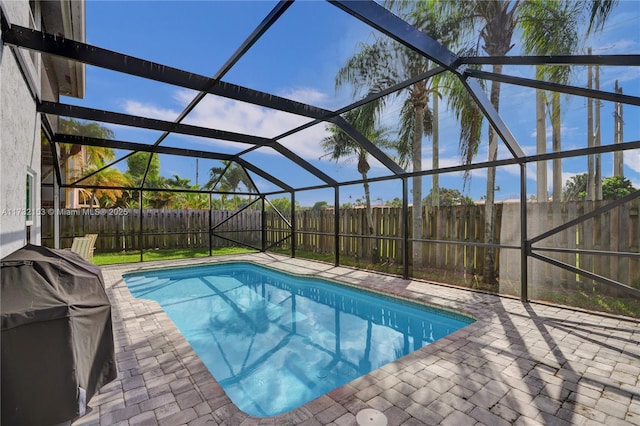 view of swimming pool featuring grilling area, a lanai, and a patio