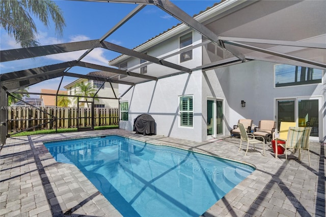 view of pool with a patio area and glass enclosure