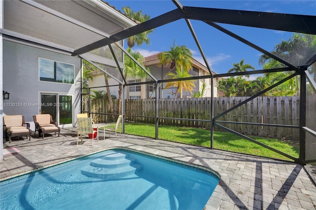 view of pool featuring a lawn, a patio, and glass enclosure