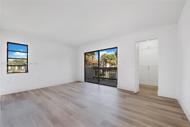 unfurnished room featuring plenty of natural light and light hardwood / wood-style floors