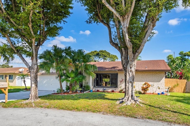 ranch-style home with a garage and a front lawn