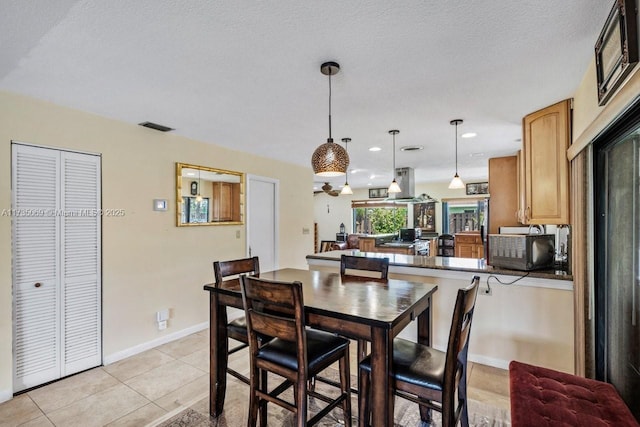 tiled dining room featuring a textured ceiling