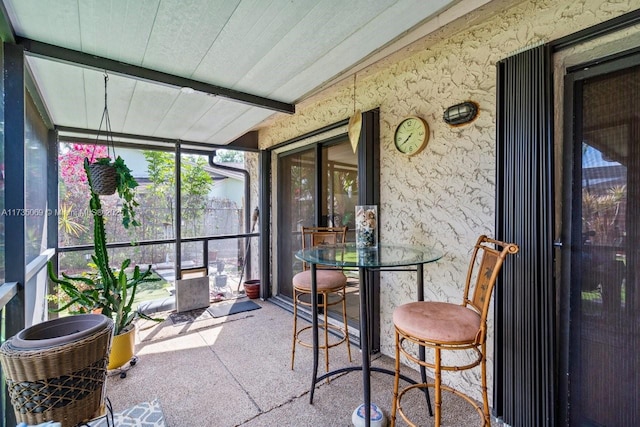 sunroom / solarium featuring beam ceiling