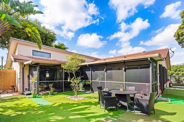 rear view of property with a sunroom and a lawn