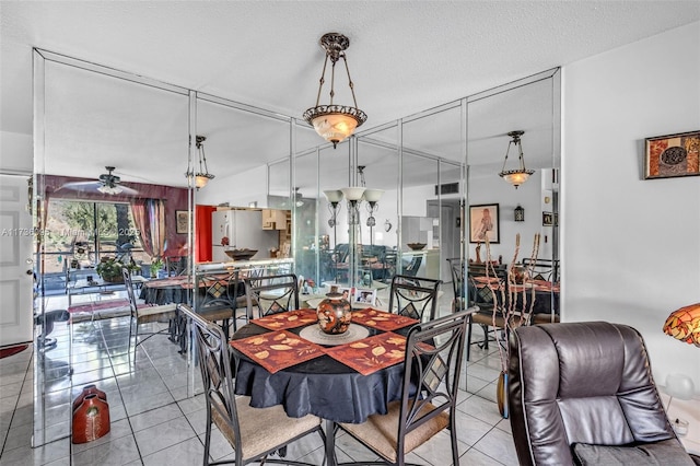 tiled dining space with ceiling fan and a textured ceiling