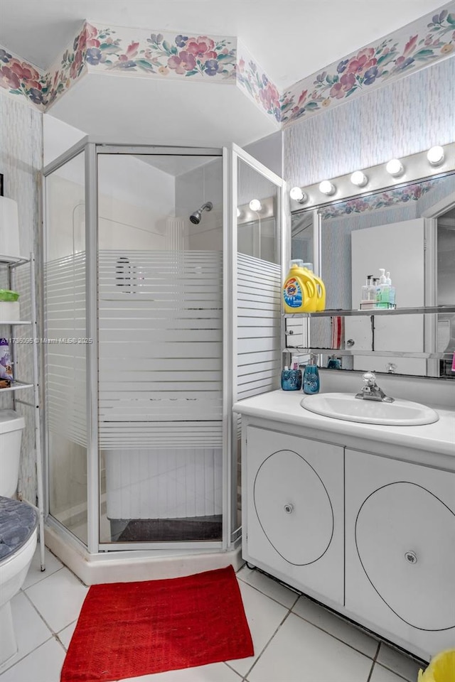 bathroom featuring tile patterned floors, toilet, an enclosed shower, and vanity