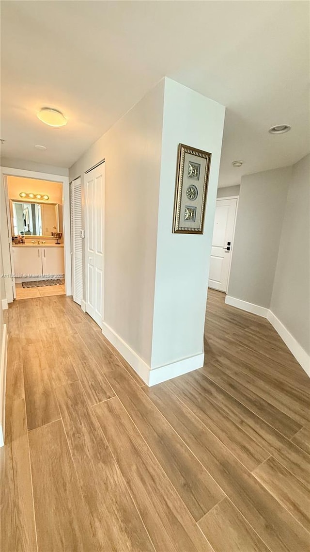 corridor with hardwood / wood-style flooring