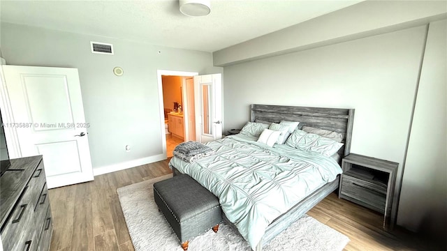 bedroom featuring a textured ceiling and light hardwood / wood-style floors