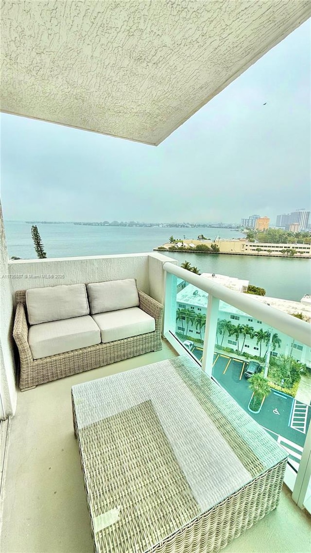 balcony featuring a water view and an outdoor hangout area