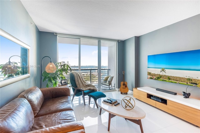 tiled living room featuring floor to ceiling windows and a textured ceiling