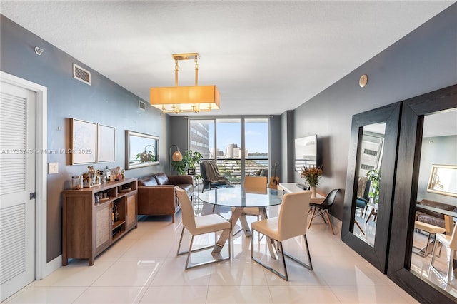 tiled dining space featuring floor to ceiling windows