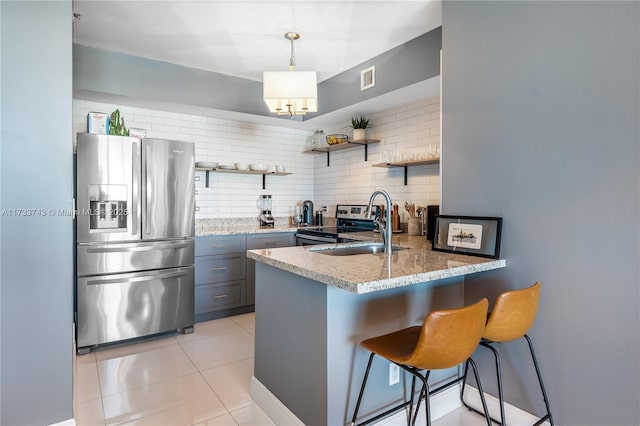 kitchen with sink, hanging light fixtures, stainless steel appliances, tasteful backsplash, and kitchen peninsula