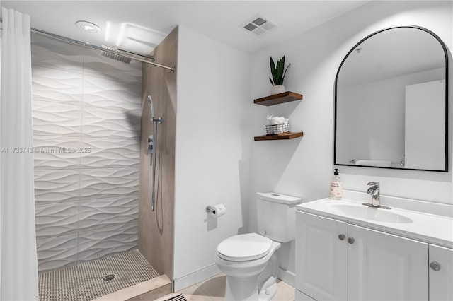 bathroom with vanity, toilet, and a tile shower