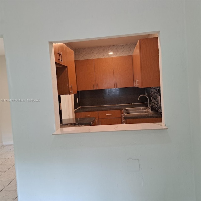 kitchen featuring sink, light tile patterned floors, and decorative backsplash