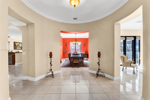 hall featuring a healthy amount of sunlight, light tile patterned flooring, and crown molding