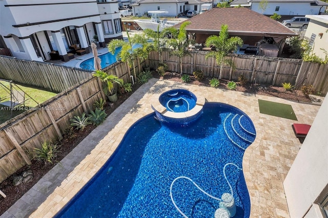 view of pool with an in ground hot tub and a patio