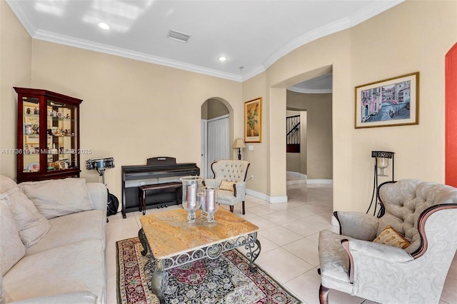 living area with arched walkways, crown molding, visible vents, light tile patterned flooring, and baseboards